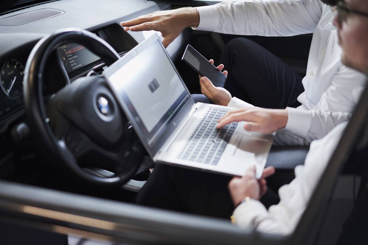 Huf engineers sitting inside a car and tracking the performance of the digital key solution Phone as a Key